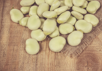 Green fresh broad beans on old wooden table.
