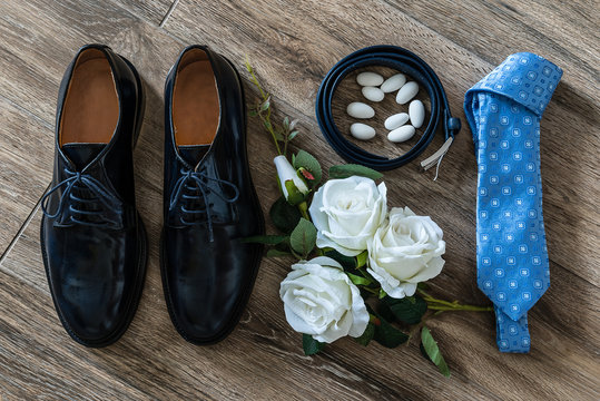 Scarpe da sposo con accessori e decorazioni floreali