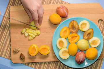 Hand cuts fruit on a wooden board