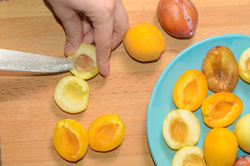 Hand cuts fruit on a wooden board