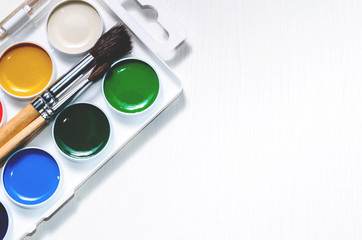 Watercolors and brushes on a white background
