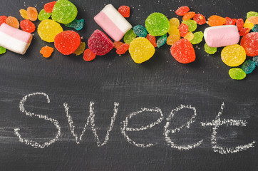 Bright colored candy, sweets, sweets on a dark background, top view