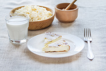 Cottage cheese casserole with sugar powder and a glass of milk