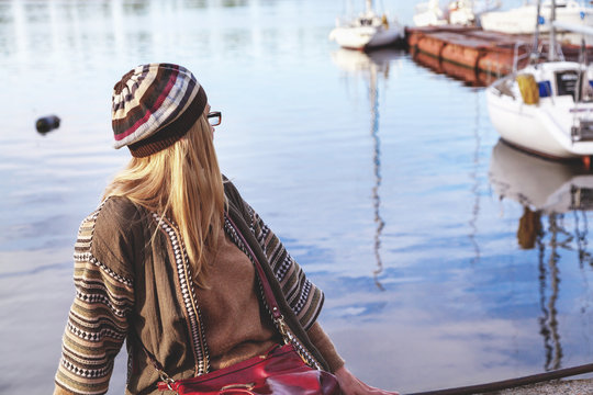 girl in a beret and glasses sits on the Bay