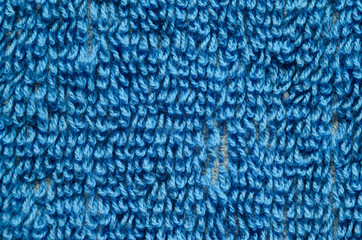 Macro shot of a blue towel. Texture is similar to the texture of a fleecy knotted-pile carpet. Geometric pattern of villi on fabric material