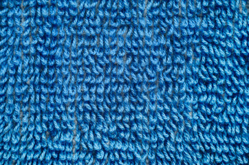 Macro shot of a blue towel. Texture is similar to the texture of a fleecy knotted-pile carpet. Geometric pattern of villi on fabric material