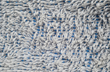 Macro shot of a white towel. Texture is similar to the texture of a fleecy knotted-pile carpet. Chaotically directed white villi on a blue basis