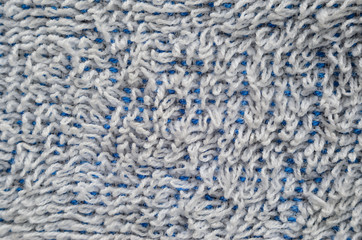 Macro shot of a white towel. Texture is similar to the texture of a fleecy knotted-pile carpet. Chaotically directed white villi on a blue basis