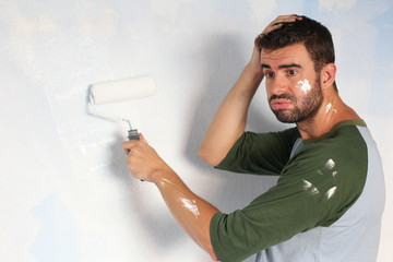 Stressed out male painting his home with space for copy