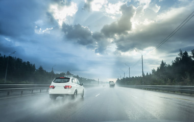 Drive car in rain on asphalt wet road. Clouds and sun