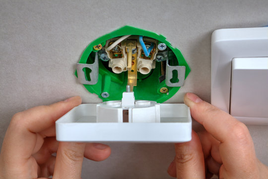 Installation of wall socket in the junction box, hands closeup.