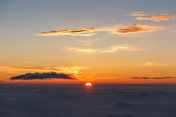 Fototapeta na wymiar Sunrise above clouds and warm sky.