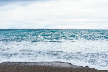 selective focus Soft waves foam in blue ocean italy coast, summer evening as background
