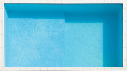 Vista aerea in primo piano di una piscina azzurra piena d'acqua pulita. Intorno a fare da bordo...