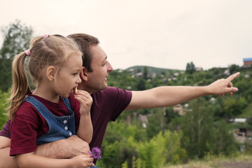 Father and daughter on a hill