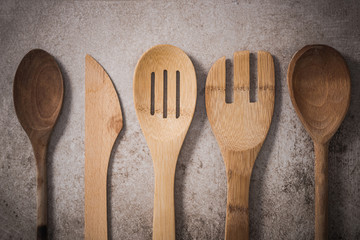 Vintage wooden kitchen utensils, flat lay on stone slate