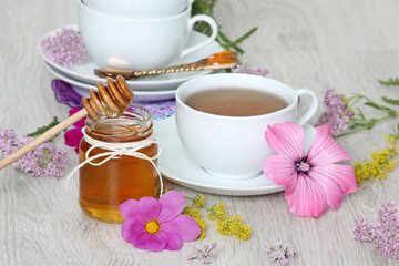 Fototapeta na wymiar Cup of tea with honey and summer flowers 