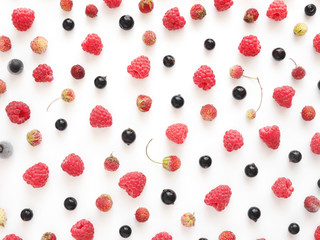 Composition of fresh berries: raspberry, strawberry, black currant on a white background. Food pattern background. Healthy food concept. Top view, flat lay.