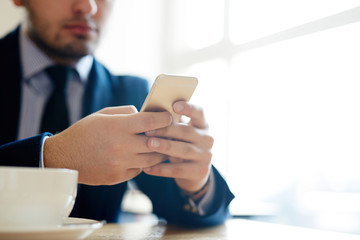 Businessman using smartphone while sitting in cafe