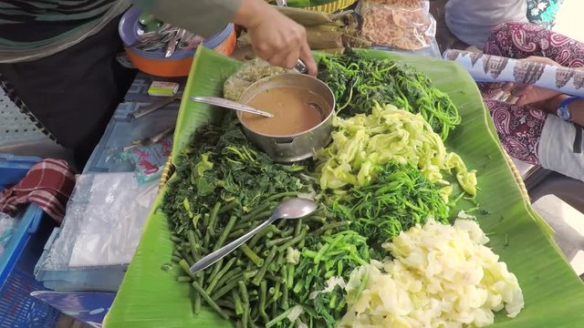 Yogyakarta, Indonesia. August 02, 2017: Video footage of seller makes Pecel Indonesian traditional food from boiled vegetables and peanut sauces