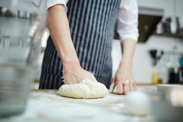 Obraz na płótnie Canvas Pastry chef kneading fresh dough for buns