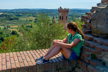 Fototapeta premium Chica joven posando encima de un paisaje Toscano