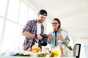 Stock photographer and his assistant discussing new shots