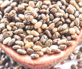 Chia seeds in wood spoon on a white background