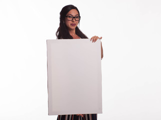 Young confident woman portrait of a confident businesswoman showing presentation, pointing placard gray background. Ideal for banners, registration forms, presentation, landings, presenting concept.