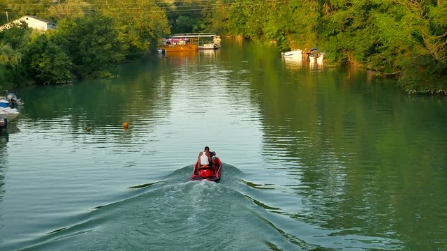 Men ride a hydrocycle on the lake's river nature.