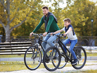 Fototapeta na wymiar Dad and son riding bicycles outdoors