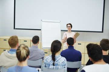 Fototapeta na wymiar Teacher by whiteboard explaining students principles of successful business