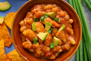 Bowl with delicious turkey chili on table, close up