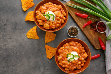 Two bowls with delicious chili turkey on grey background