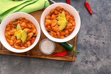 Two bowls with delicious chili turkey on wooden board