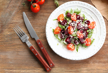 Plate with useful beet salad on wooden background