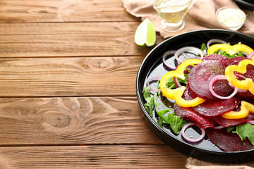 Plate with useful beet salad on wooden background