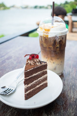 chocolate cake with cherry topping and ice coffee mocha in outdoor cafe