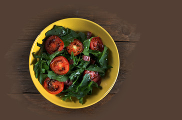 Vegetable salad with tomatoes and arugula on the table