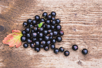 Background of berries is black currant on a wooden table.