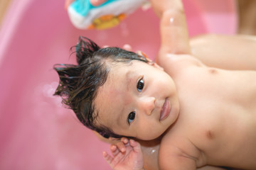Obraz na płótnie Canvas Asian new born having a bath by mother