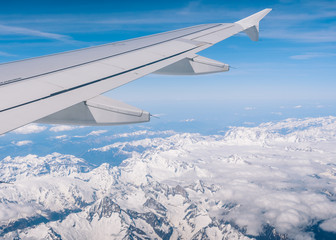 Fototapeta na wymiar Outside airplane window to mountain landscape