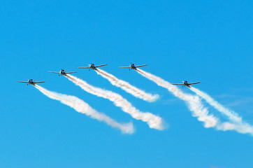 Aerobatic team aircraft fighters trail of smoke in the sky