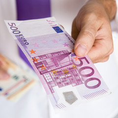 Businessman's hand giving an euro banknote. Dealing with big money. 