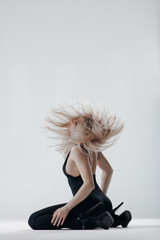 Young beautiful dancer is posing in studio