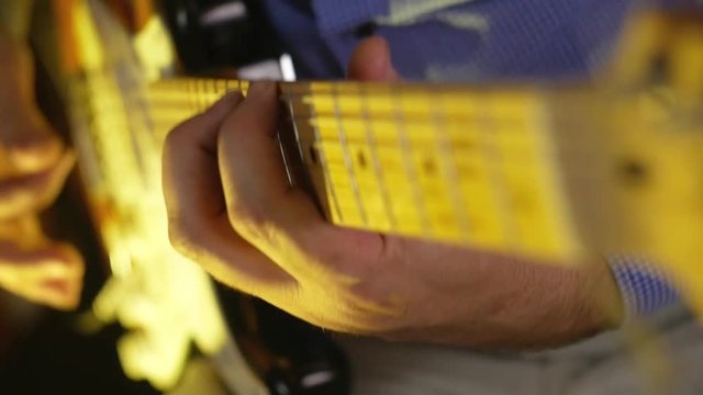 Musician plays solo by electric guitar distortion overdrive at the studio close-up