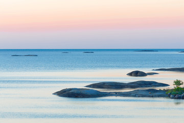 Islets in the archipelago during the sunrise. Red and blue shades