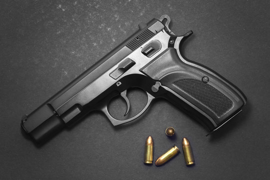 Handgun with ammunition on dark background 