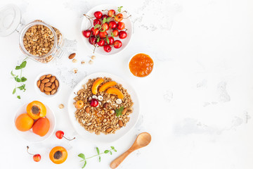 Breakfast with muesli, fruits, berries, nuts on white background. Healthy food concept. Flat lay, top view, copy space