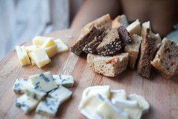Cheese DorBlu, brie and cheddar and bread on wooden plate